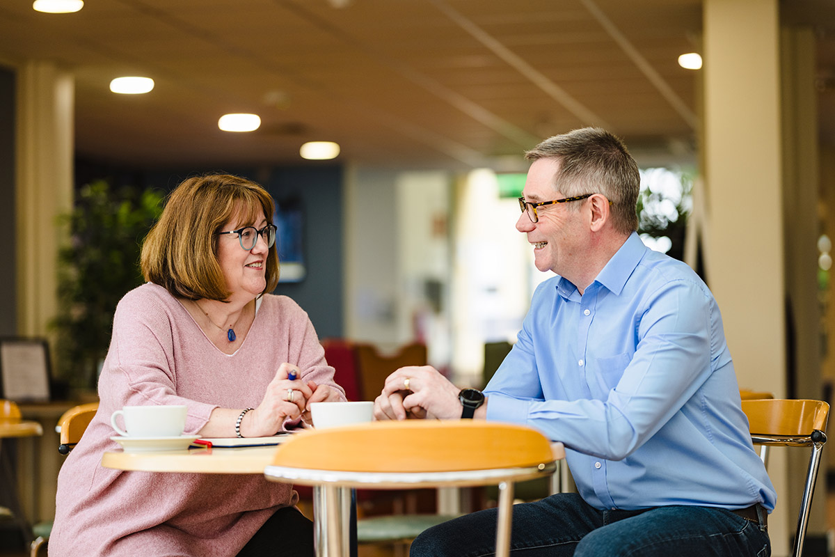 Rupert and Angela chat over coffee