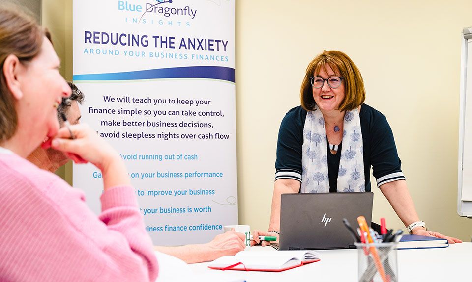 Angela in a presentation leaning on desk