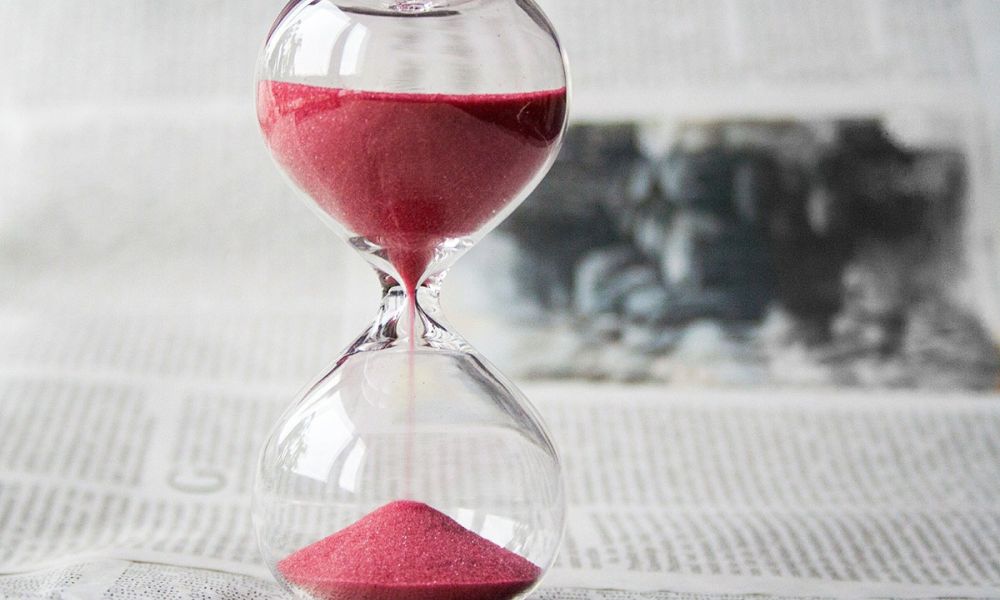 black and white picture with sand timer, the sand is red