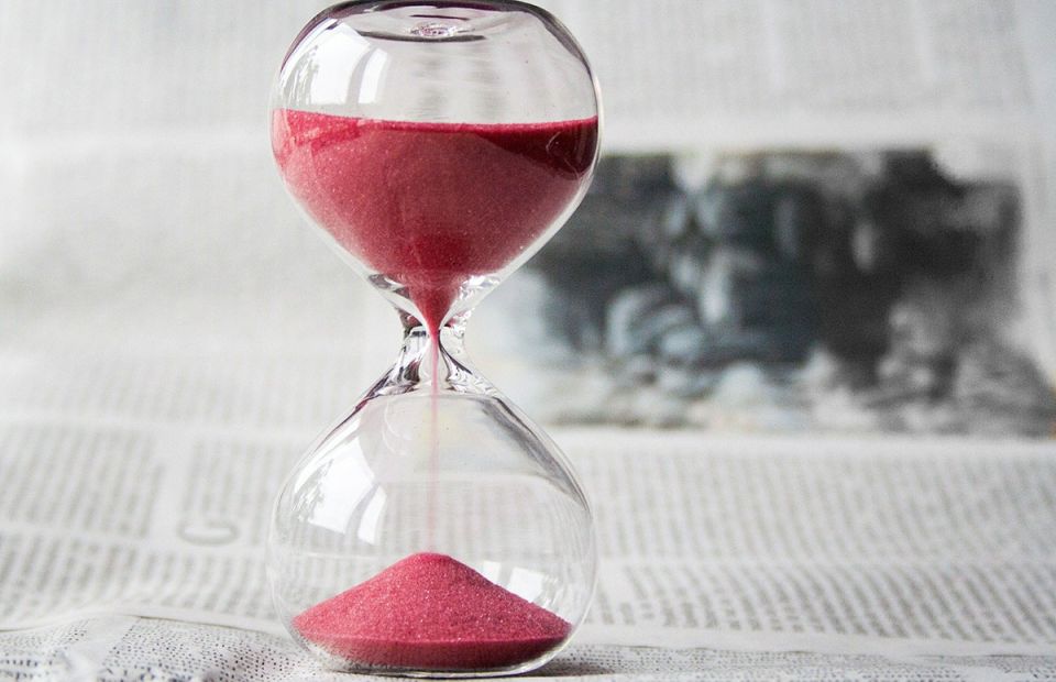 black and white picture with sand timer, the sand is red
